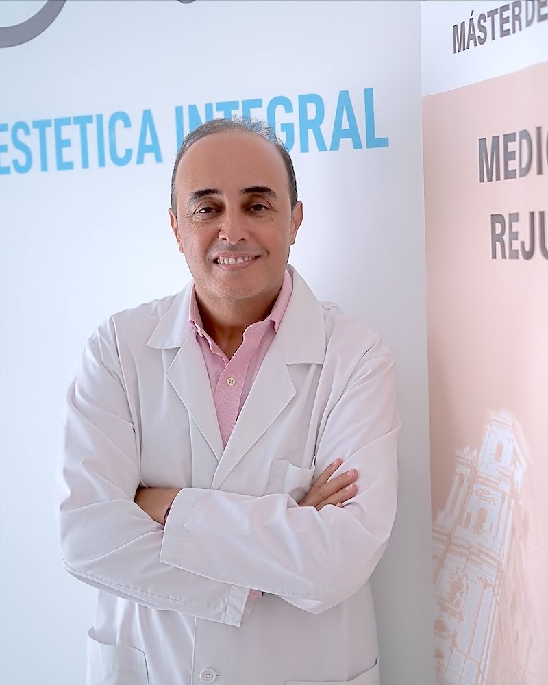 Dr. Jaouad Oulkadi junto al cartel del Máster de Formación Permanente en Medicina Estética y Rejuvenecimiento Integral de la Universidad Católica de Valencia
