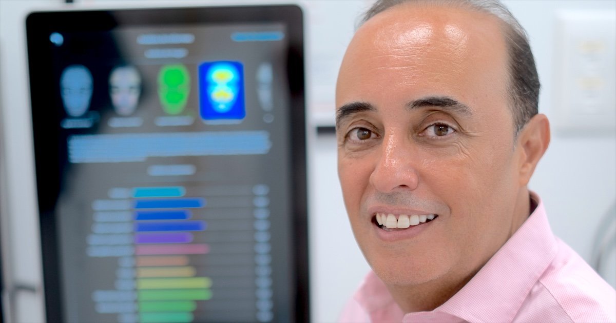 Dr. Oulkadi junto a la pantalla del analizador facial que utiliza en la primera consulta