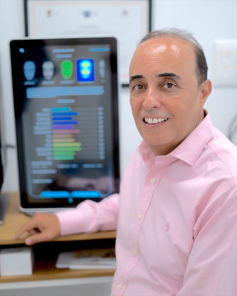 Dr. Oulkadi junto a la pantalla del analizador facial con el que valora el estado de la piel