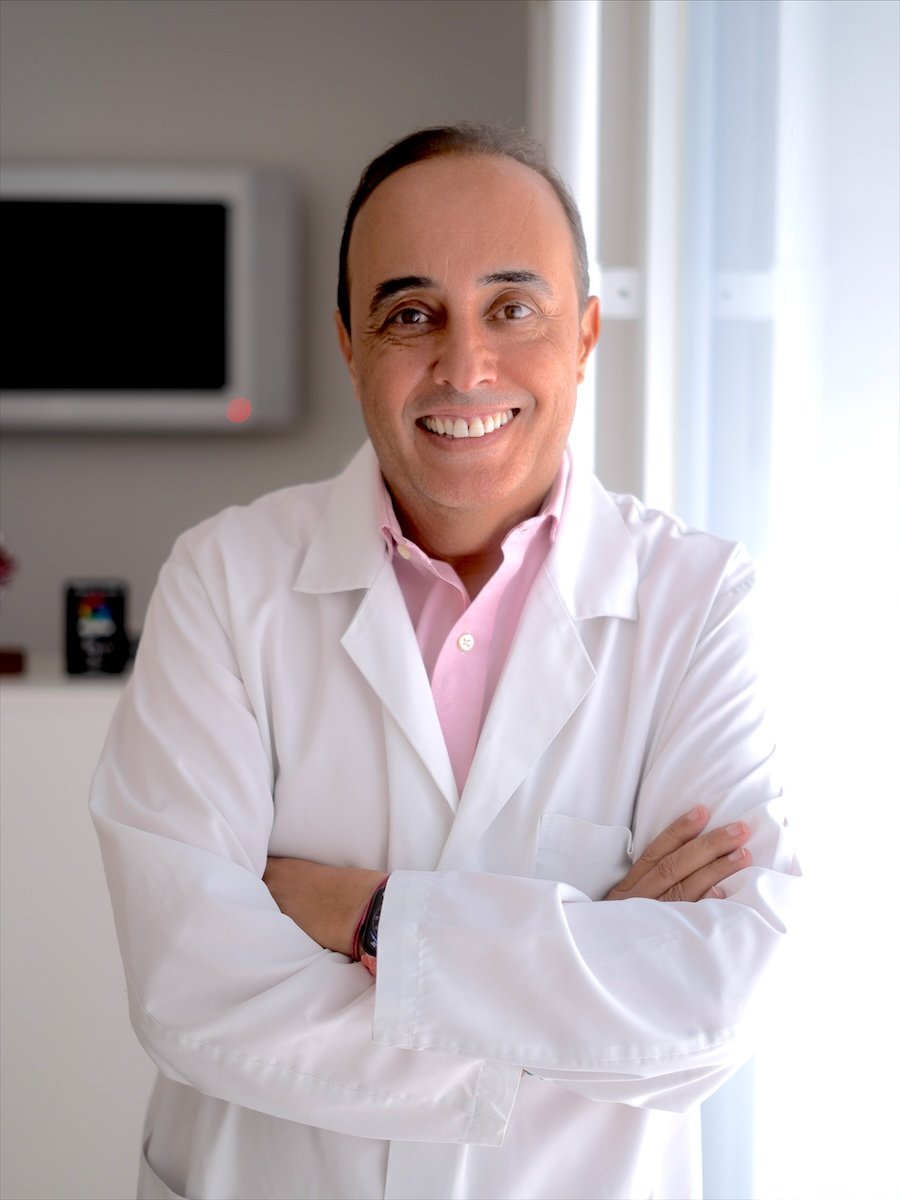 Dr. Jaouad Oulkadi Chahboun, médico estético, con bata blanca junto a la ventana de su clínica en San Pedro Alcántara (Marbella)