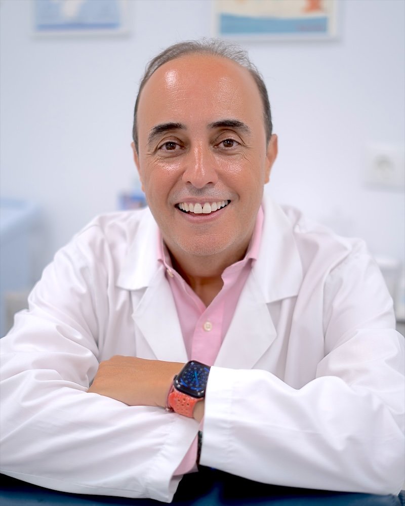 Dr. Jaouad Oulkadi sonriendo, con bata blanca, en su consulta de San Pedro Alcántara